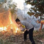 Pihak Kepolisian dan Warga Tenjo Berupaya Memadamkan Kobaran Api di Lahan Kosong 